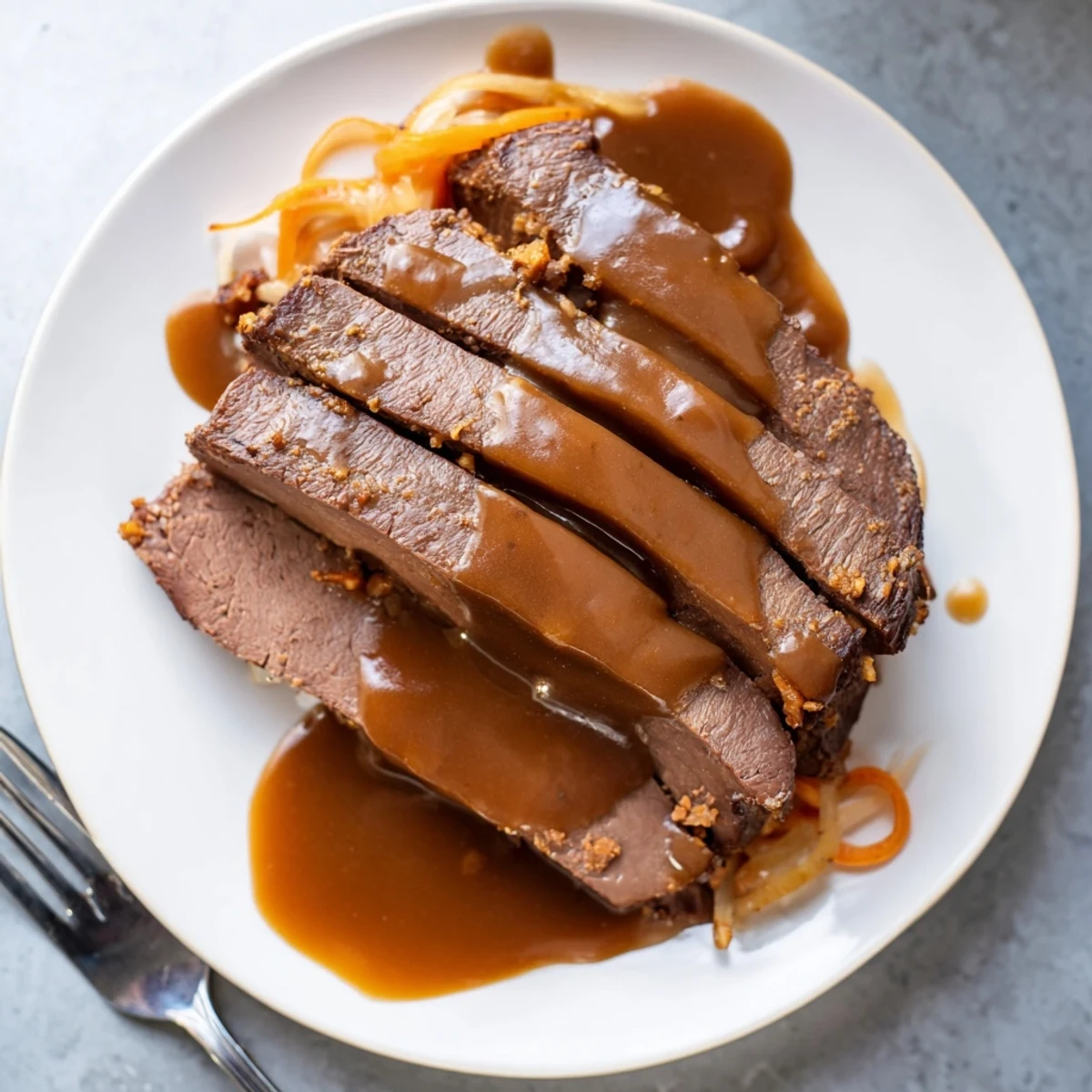 Zartes, mariniertes Rindfleisch für Easy Sauerbraten, serviert mit aromatischer Soße.  