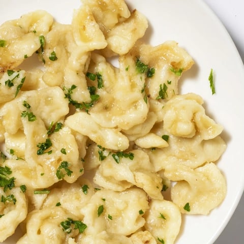 Zarte Spaetzle-Dumplings in Butter geschwenkt, ideal als Beilage zu herzhaften Gerichten.